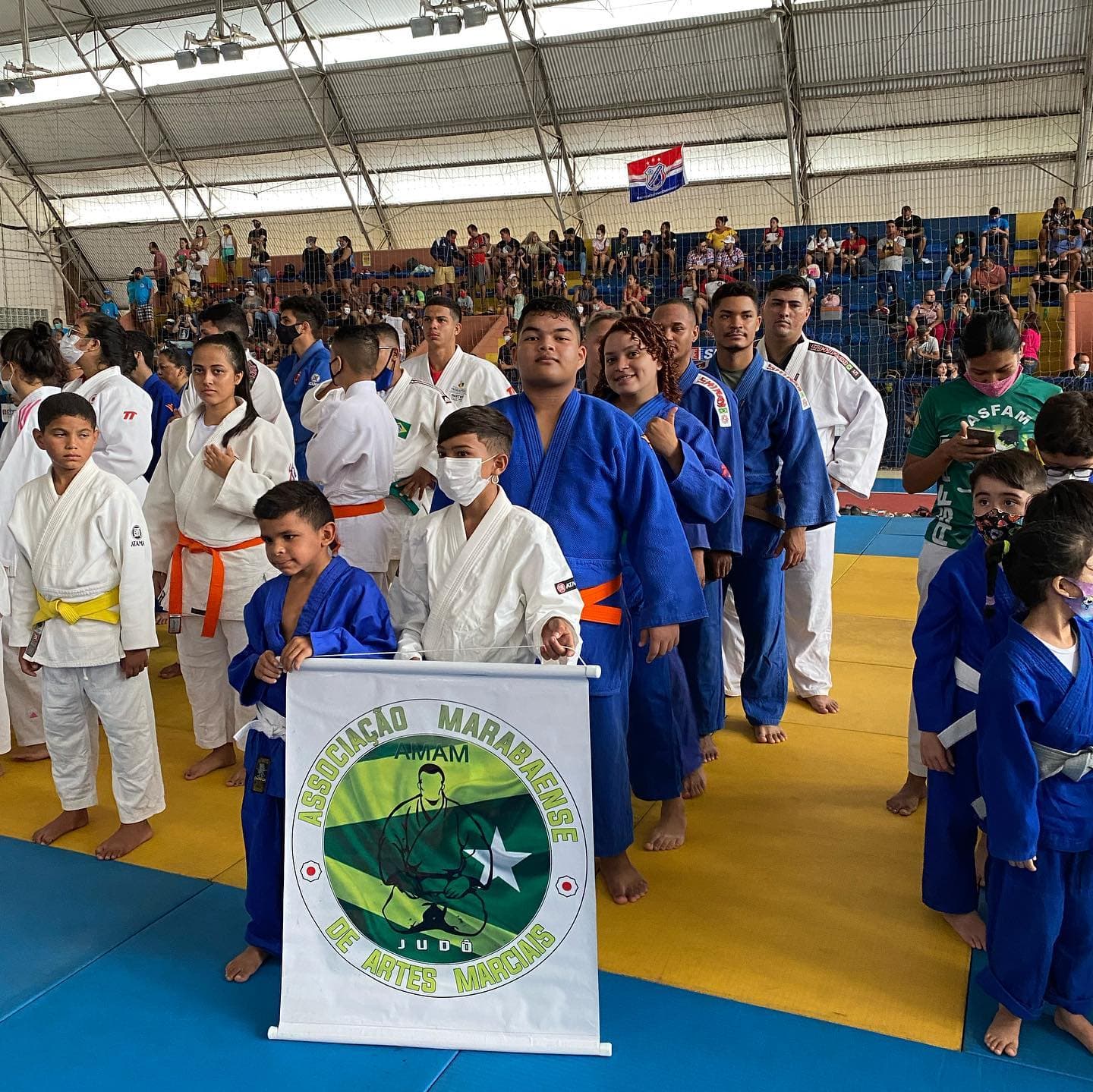 Equipe AMAM em competição com o banner da associação